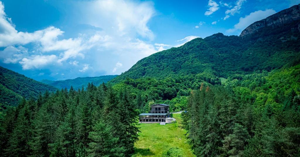 a house in the middle of a forest with mountains at Арборетум Вила & Ресторант in Teteven