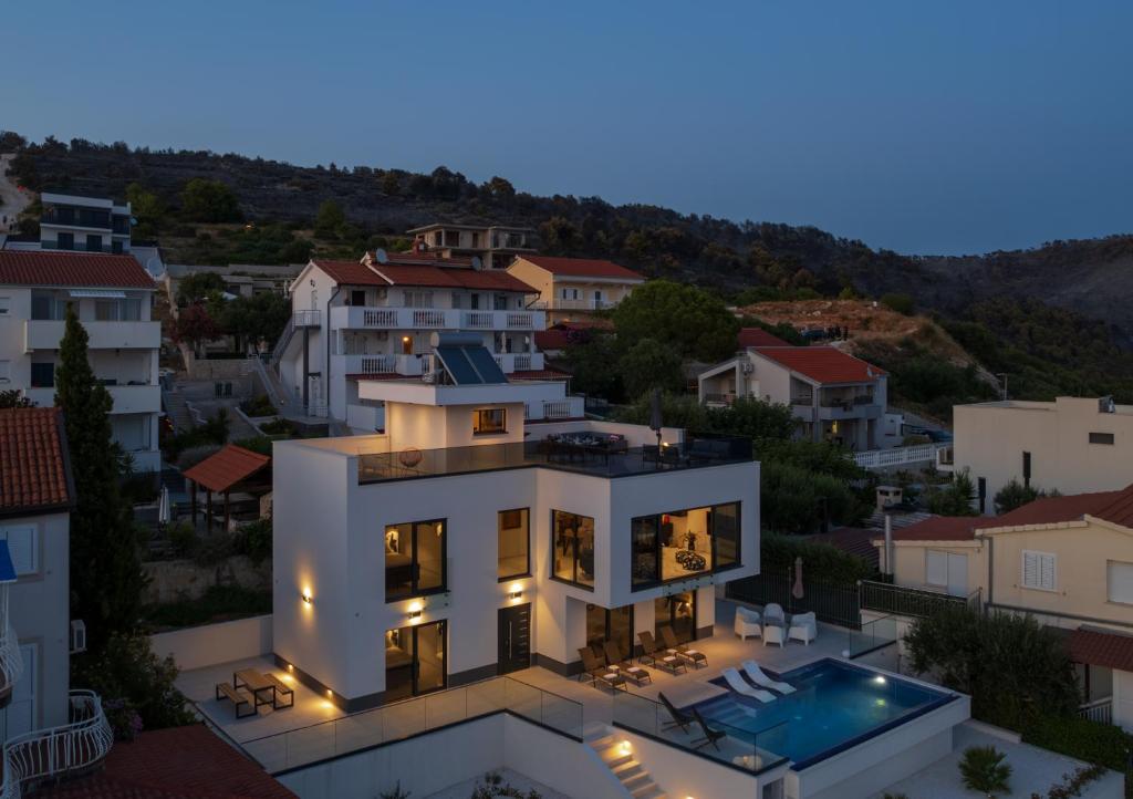 ein großes weißes Haus mit einem Pool in der Unterkunft Villa Julian with a heated pool in Trogir