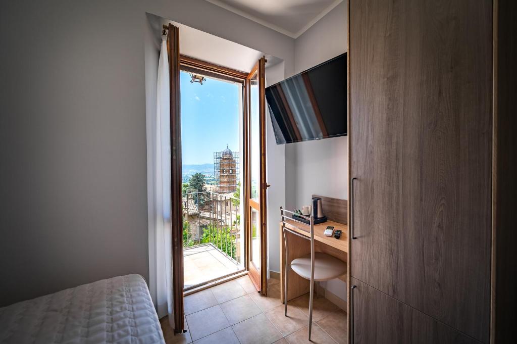 una camera con letto e finestra con vista di Roof Garden Rooms ad Assisi