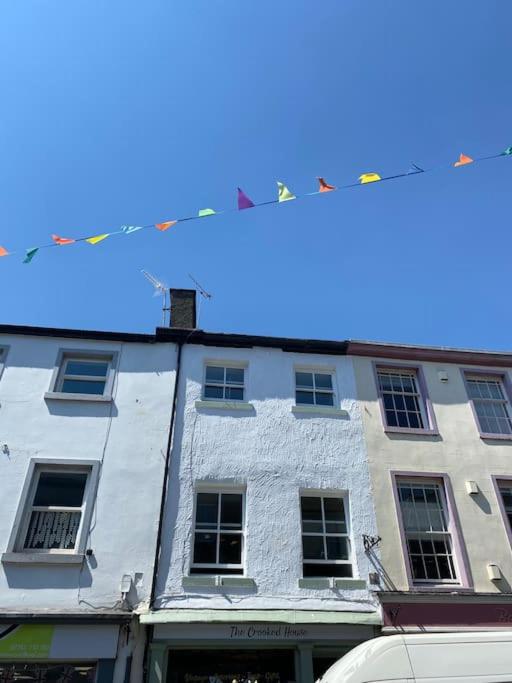 a tall white building with clothes line in front of it at The flat at the crooked house in Ulverston