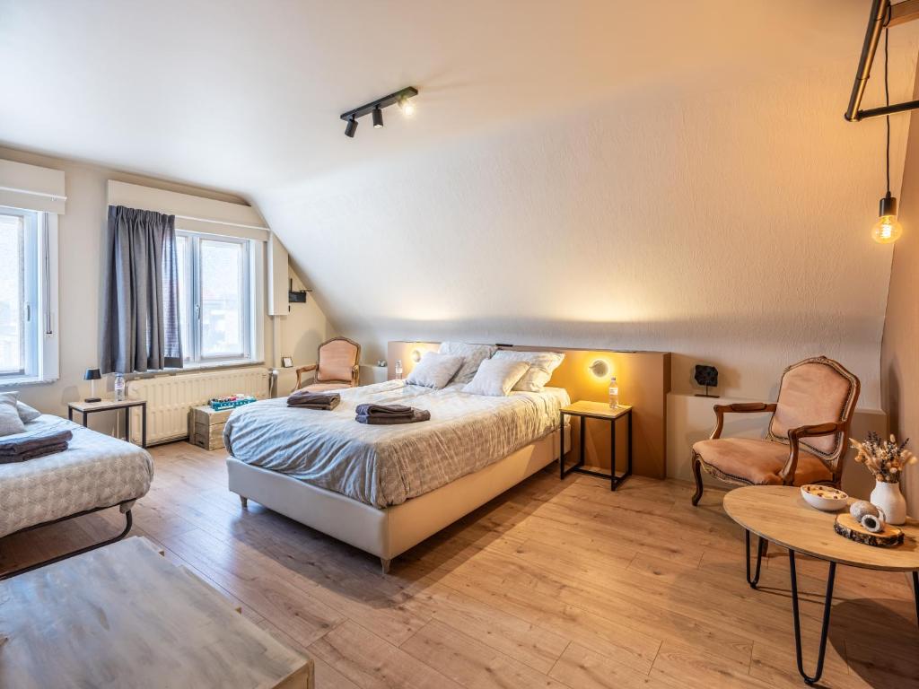 een slaapkamer met een bed, een stoel en een tafel bij Séjour14 -- Gastenverblijf - volledige 1e verdiep in Veurne