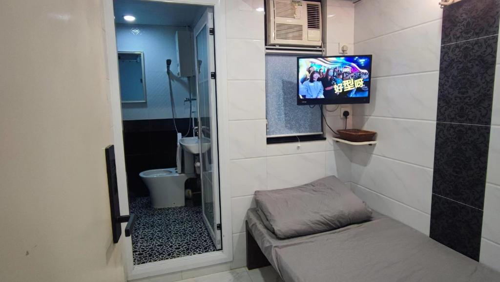 香港Tsim Sha Tsui Bedrooms的一间带电视和卫生间的小浴室