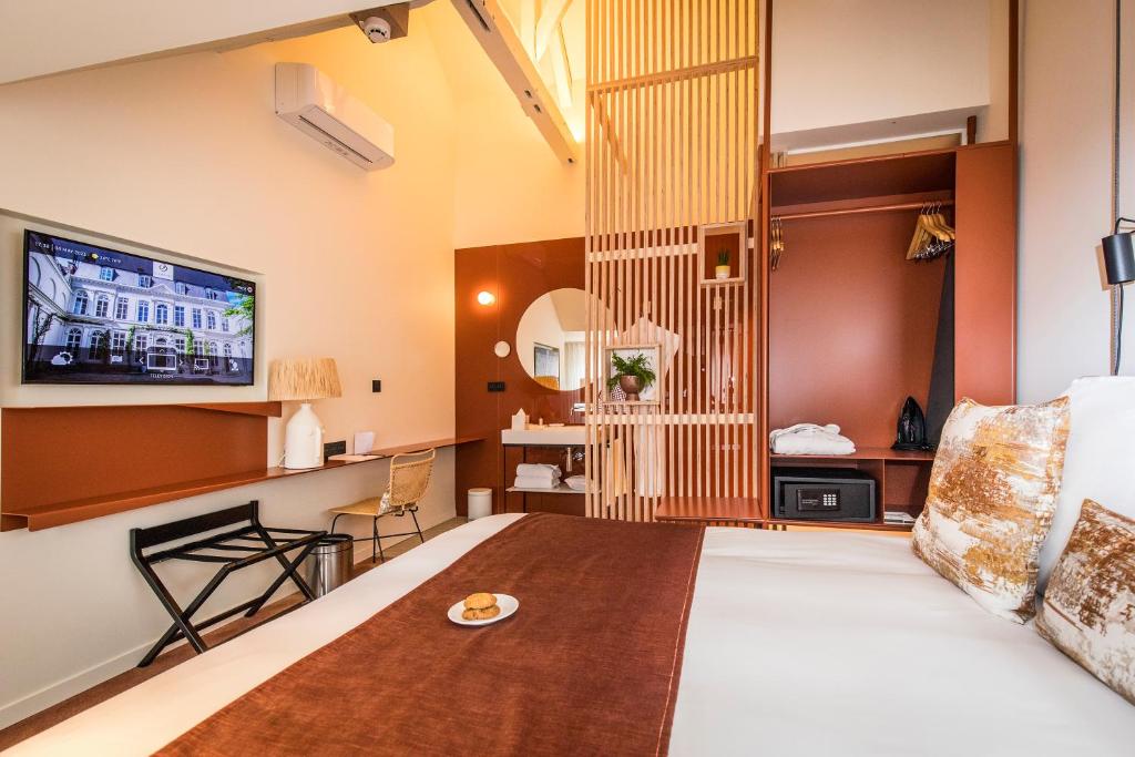a hotel room with a bed and a tv at Clarance Hotel Lille in Lille