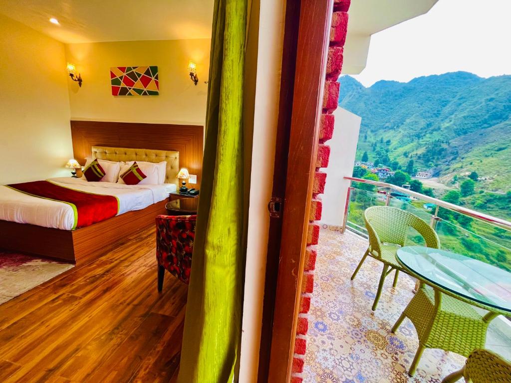 a hotel room with a bed and a balcony at Kempty Myst Resort, Mussoorie - A Comfortable Stay in Mussoorie