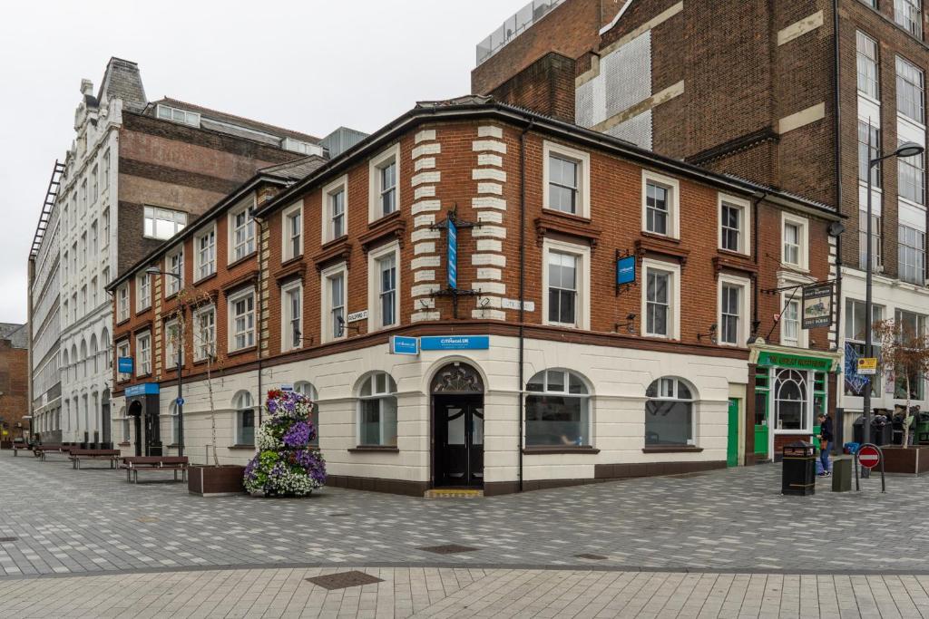 un edificio con una estatua de flores delante de él en CiTi Hotel London Luton, en Luton