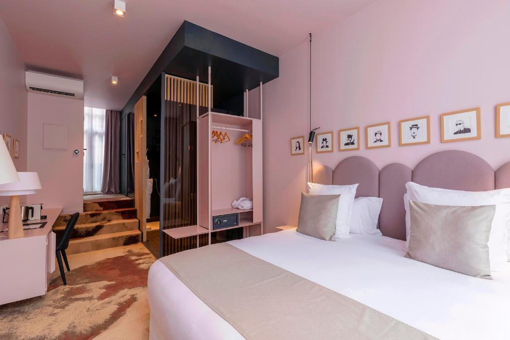 a bedroom with a large white bed and a desk at Clarance Hotel Lille in Lille