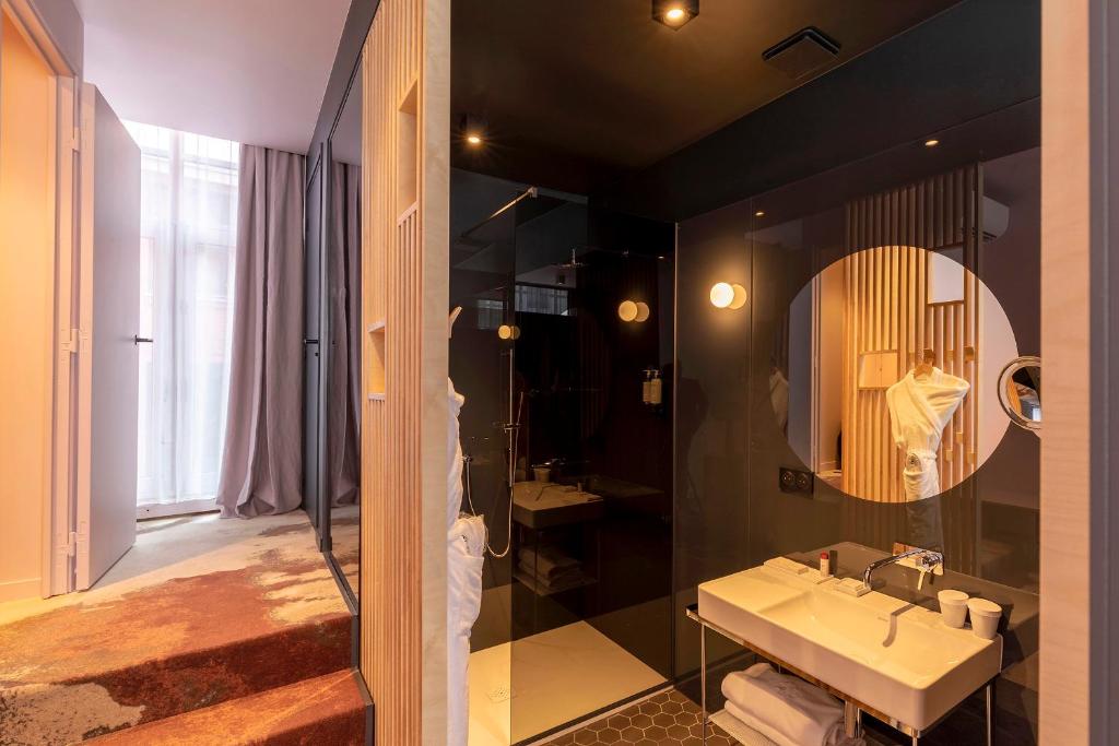 a bathroom with a sink and a mirror at Clarance Hotel Lille in Lille