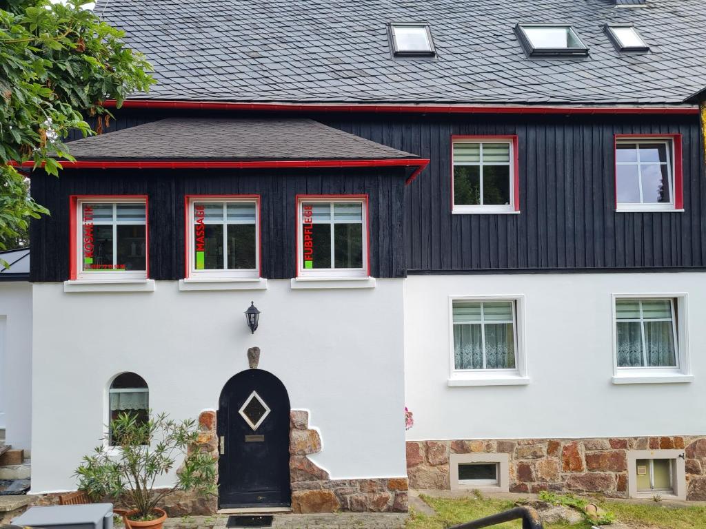 een zwart-wit huis met een zwart dak bij Haus Fernblick in Kurort Bärenburg