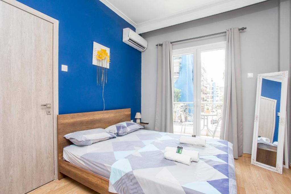 een slaapkamer met een groot bed met een blauwe muur bij Closer "Egnatia Apartment 2" in Thessaloniki