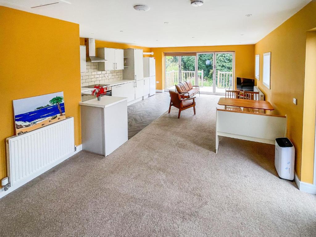 a large living room with yellow walls and a kitchen at Frankland Farm in Durham