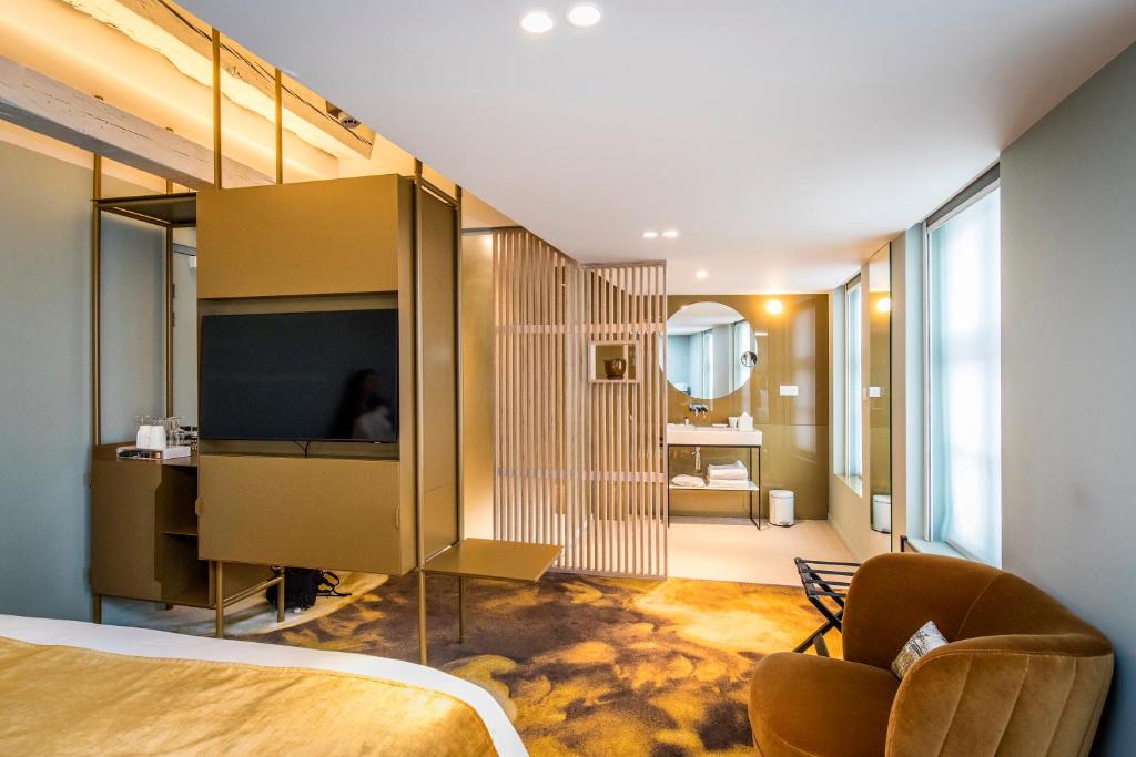 a bedroom with a bed and a television in a room at Clarance Hotel Lille in Lille