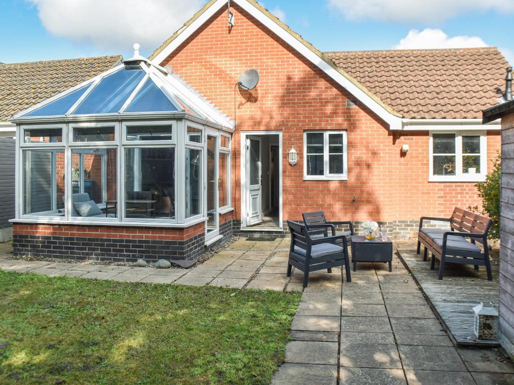 a house with a conservatory on a patio at Beach Bungalow in Belton