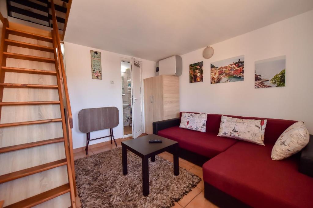 salon z czerwoną kanapą i stołem w obiekcie Anne Apartament w mieście Năvodari
