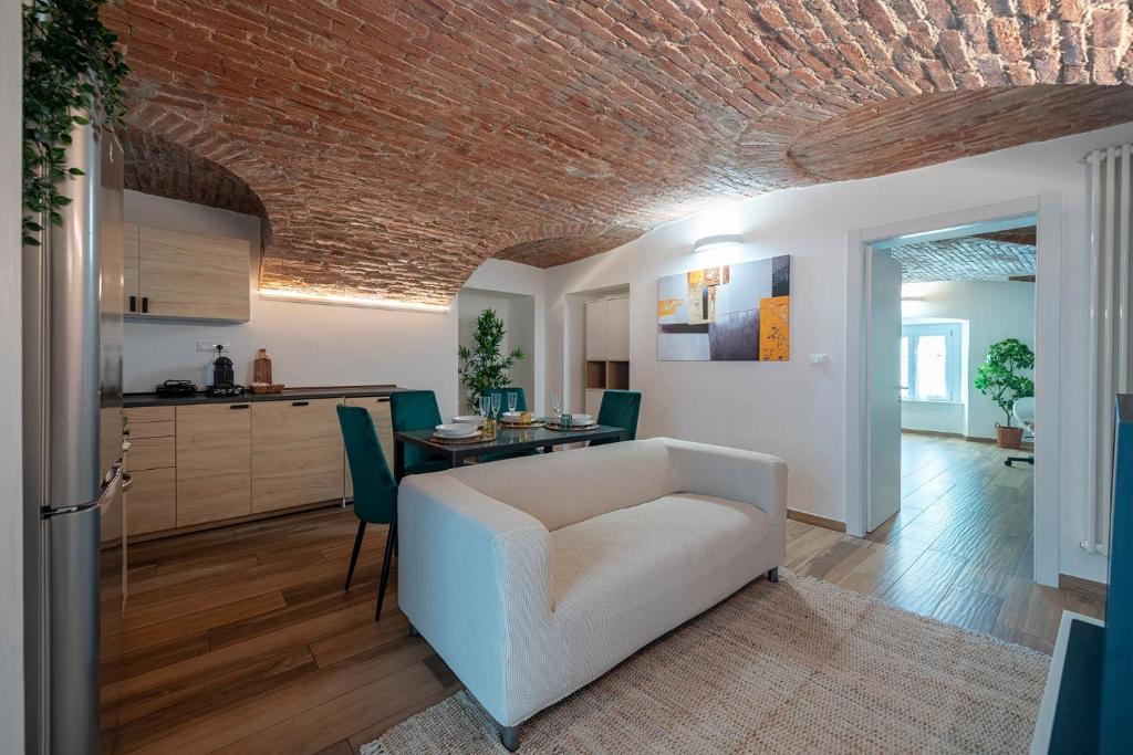 een woonkamer met een witte bank en een tafel bij [Quadrilatero Loft] Elegant Stay in Turijn