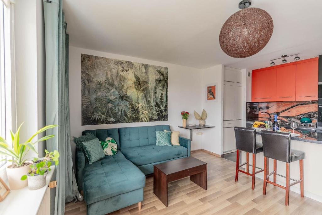 a living room with a blue couch and a kitchen at Pet’s House Warsaw in Warsaw