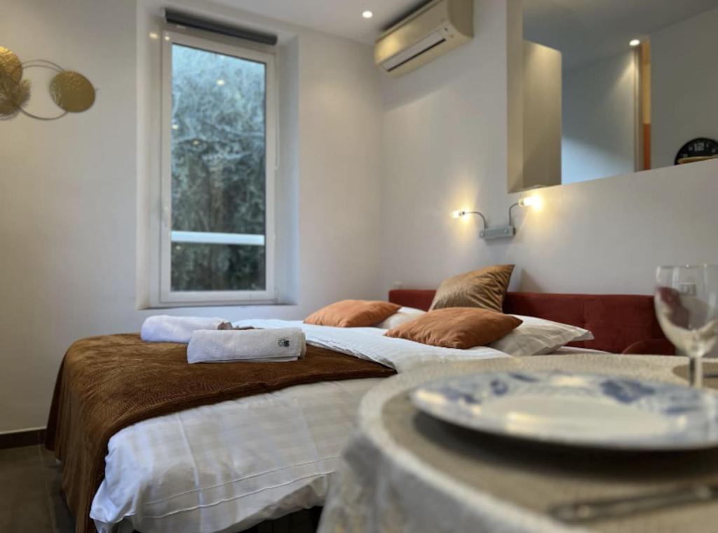 two beds in a room with a table and a window at Appartement - Cannes vieille ville - Le Suquet in Cannes