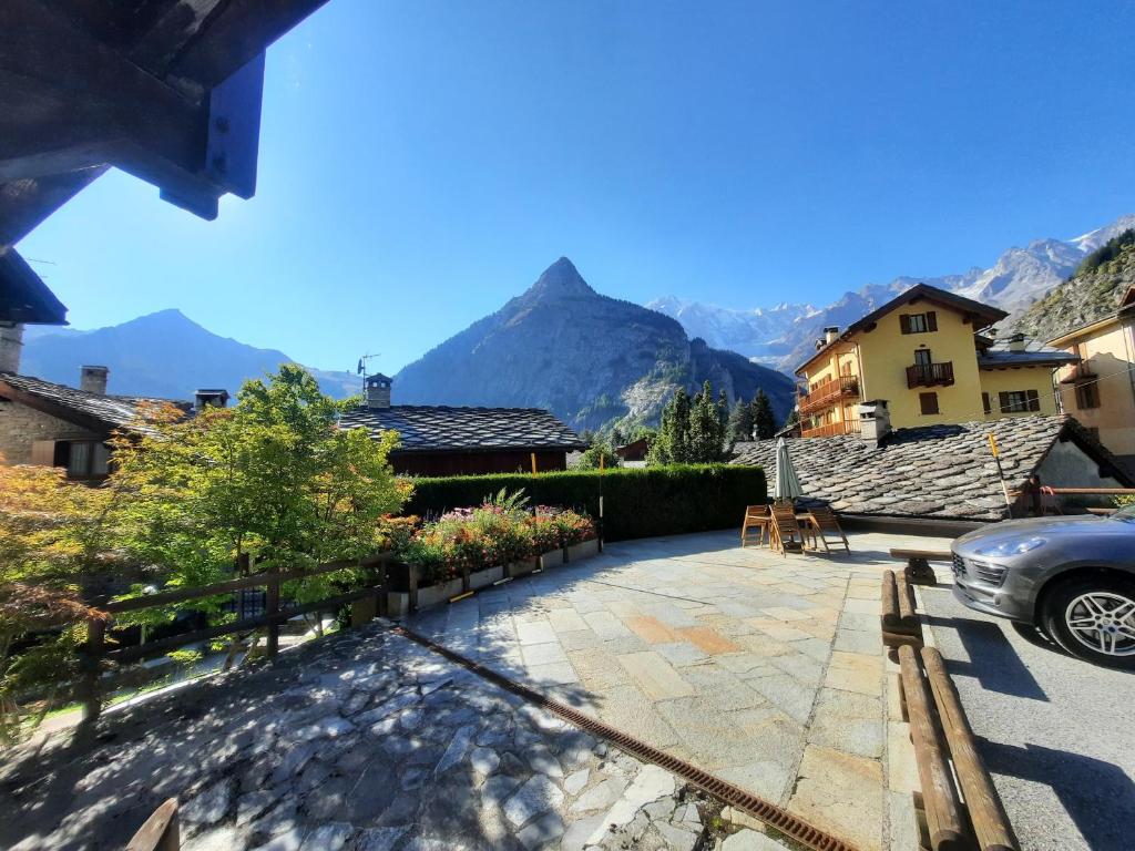 a car parked in a driveway with mountains in the background at TRILOCALE PANORAMA VISTA MONTE BIANCO in Courmayeur