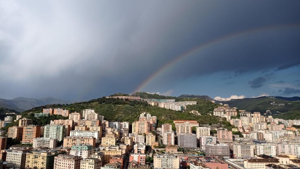 a city with a rainbow in the sky at Margin - Appartamento vicino al centro in Genoa