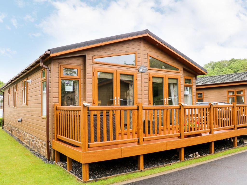 una grande cabina in legno con un ampio ponte di Hafan Lodge 85 a Narberth