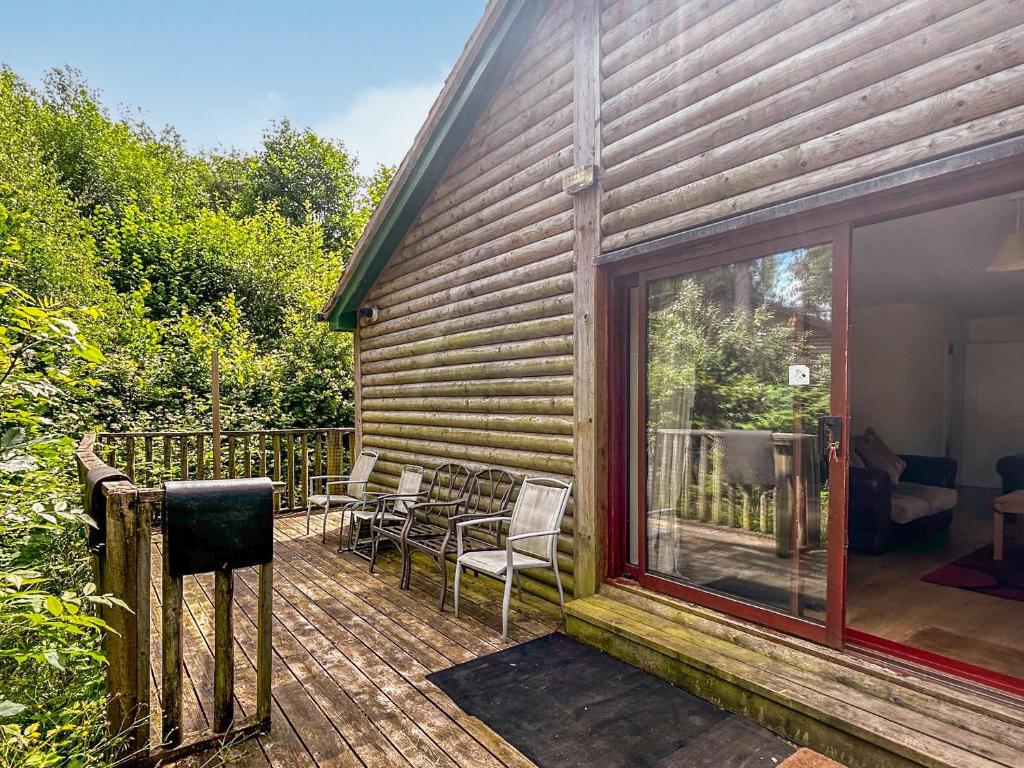 eine Terrasse mit Stühlen und einer Glasschiebetür in der Unterkunft Woodside Fishery - Kingfisher in Cleobury Mortimer