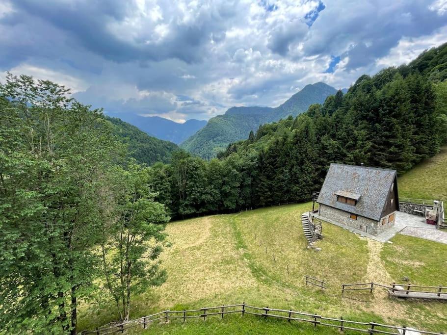 an aerial view of a barn in a field with mountains at Appartamento panoramico Casa Gerro in Averara