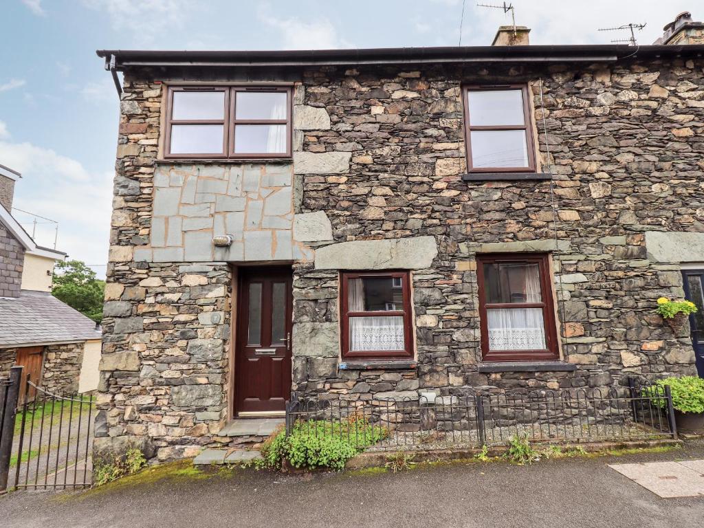 a stone house with four windows and a door at 7 Stybarrow Terrace in Penrith