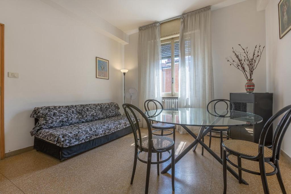a living room with a table and chairs and a couch at Bologna Rimesse & Ospedale Sant'Orsola Apartment in Bologna