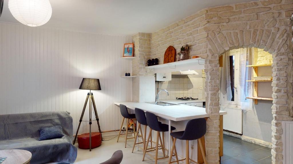 a kitchen with a table and chairs in a room at L'Episcopale - Maison 2 chambres in Albi