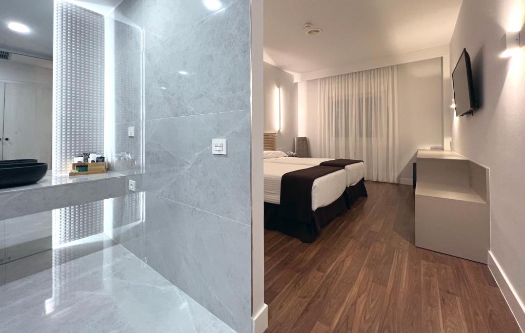 サリアにあるホテルアルフォンソIXのベッドとバスルーム付きのホテルルームです。