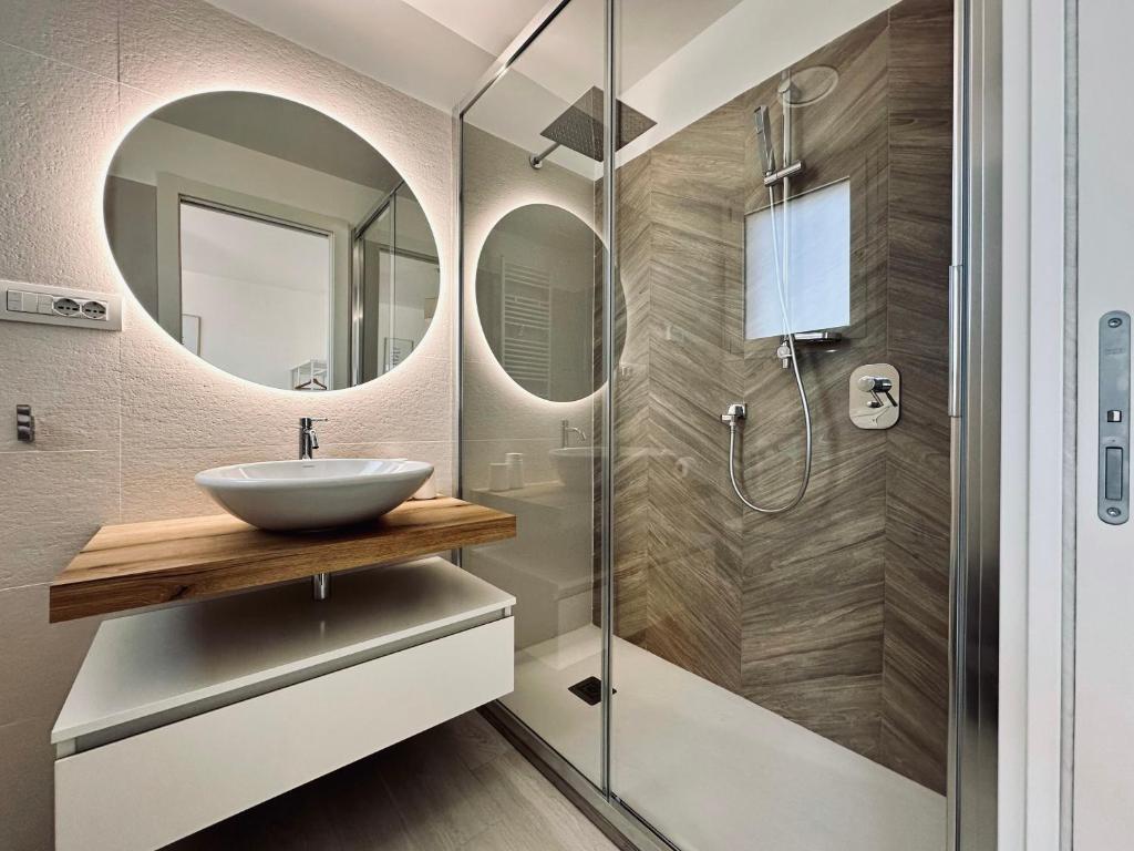 La salle de bains est pourvue d'un lavabo et d'une douche. dans l'établissement Villa Noga Rooms, à Selargius