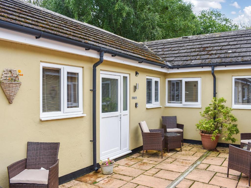 a yellow house with chairs and a white door at Teddys Cottage - Uk44685 in Burnopfield
