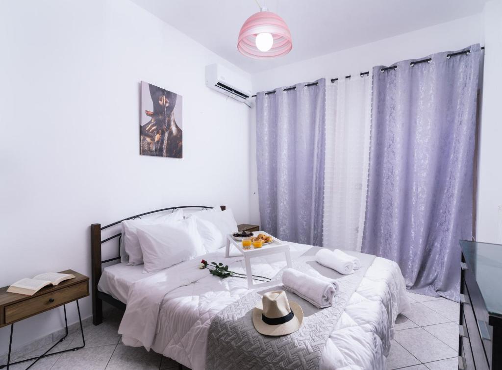 1 dormitorio con 1 cama con sombrero en Katerina Family Apartments, en Moírai