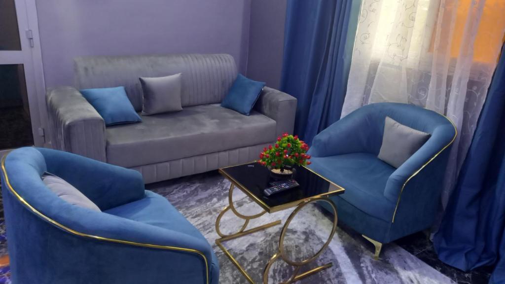 a living room with two blue chairs and a couch at Appartement Bamako ACI 2000 in Bamako