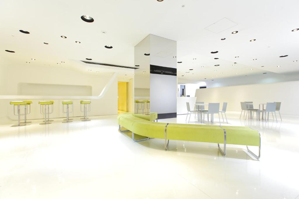 a white room with a green couch and chairs at HOTEL MYSTAYS Ochanomizu Conference Center in Tokyo