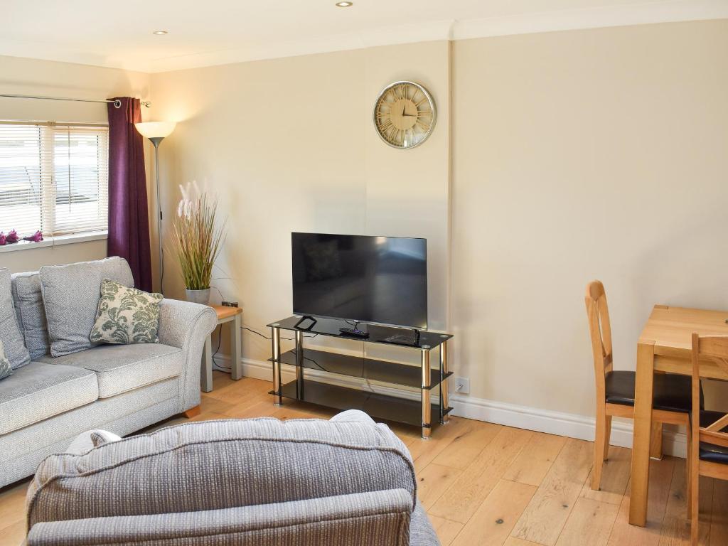 a living room with a couch and a flat screen tv at Gracies Cottage - Uk44686 in Burnopfield