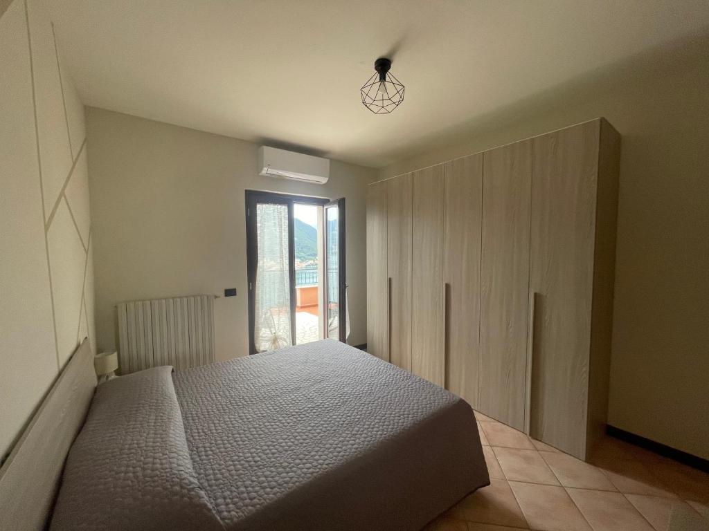 une chambre avec un lit et une grande fenêtre dans l'établissement Appartamento vista Lago d'Iseo, à Sulzano
