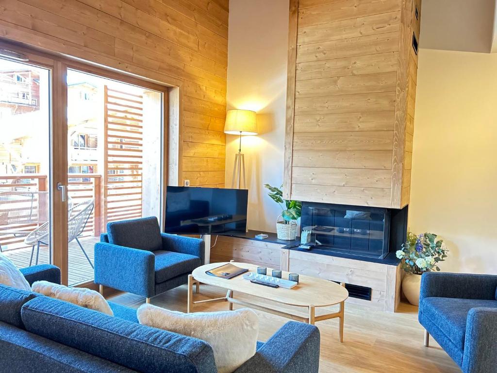 sala de estar con sofás azules y TV en Appartement Les Gets, 4 pièces, 6 personnes - FR-1-623-336 en Les Gets