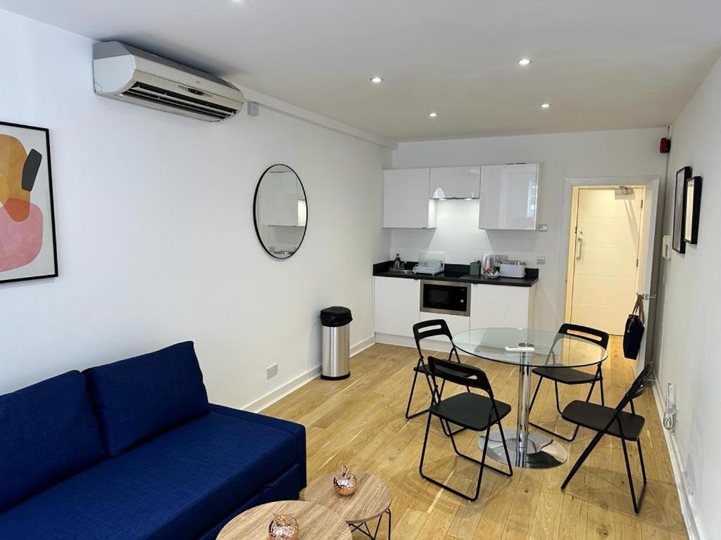 un soggiorno con divano blu e tavolo di New 2A Soho Studios by Indigo Flats Sleeps 4 a Londra