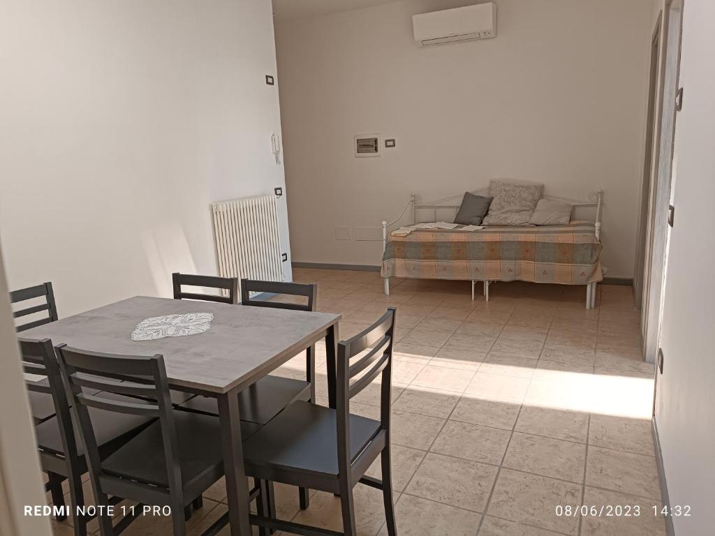 a dining room with a table and chairs and a couch at Appartamenti Garda -Luna & Sole - in Garda