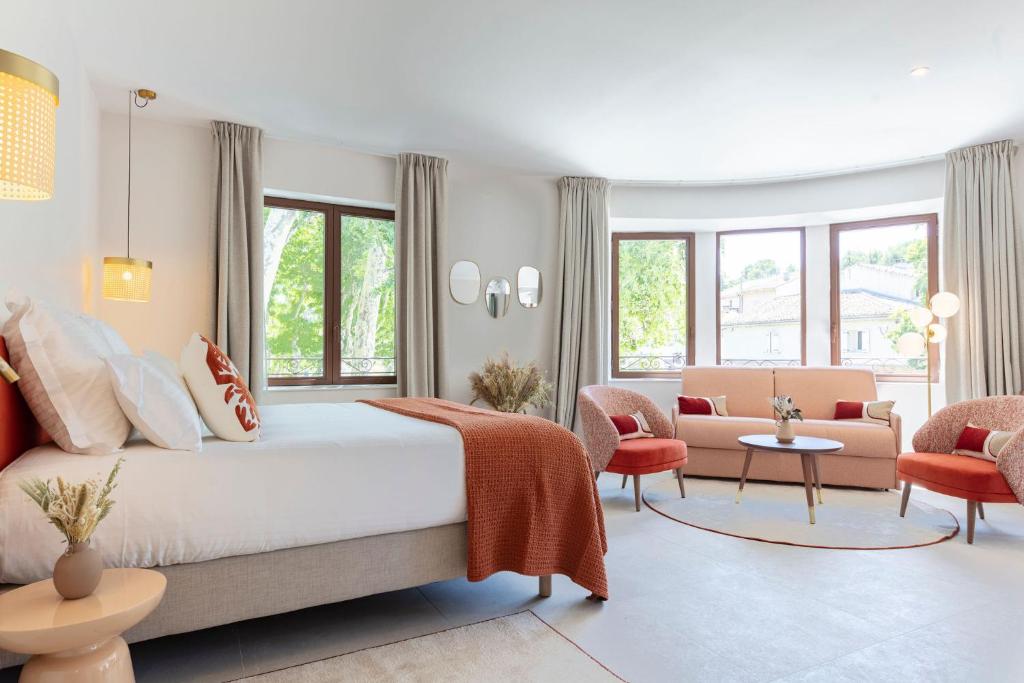 a bedroom with a bed and a living room at La Bastide Bourrelly - Mathias Dandine in Cabriès