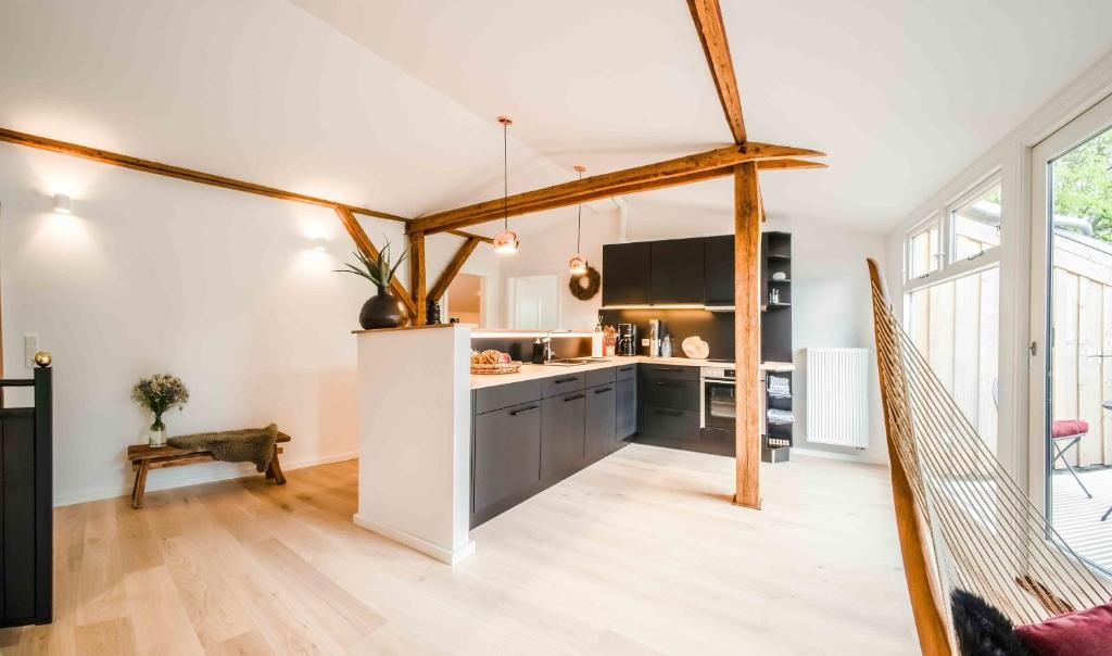 a kitchen with white walls and wooden beams at Studio EINS in Oersberg