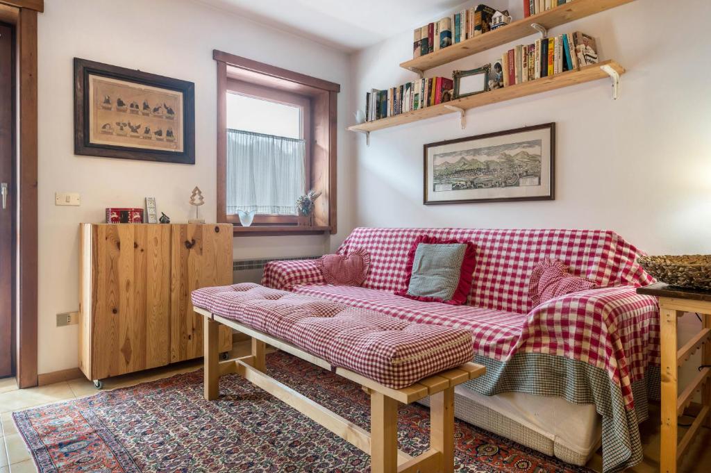 uma sala de estar com um sofá xadrez vermelho em App Negritella Villaggio Ladino em Mazzin