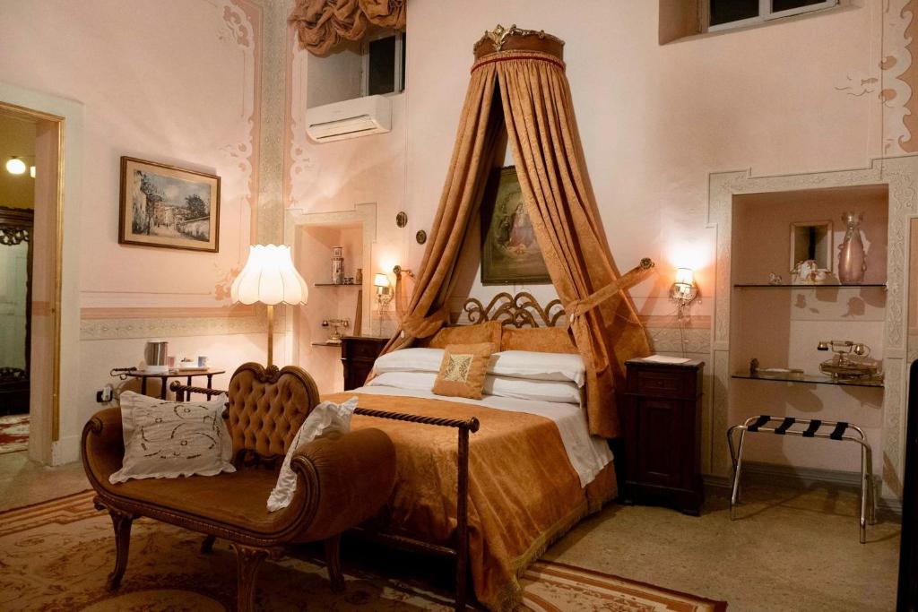 a bedroom with a canopy bed and a chair at Palazzo De Castro in Squinzano
