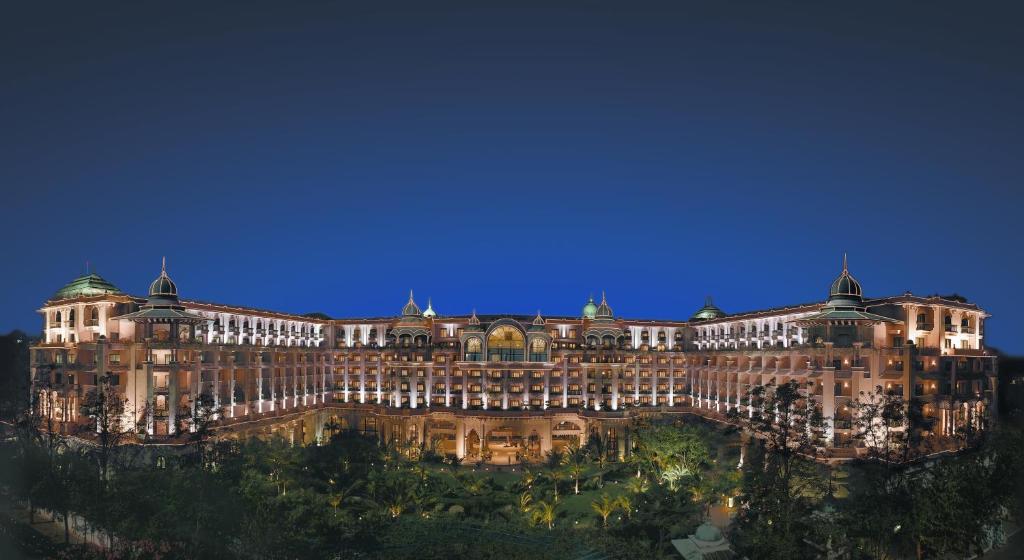 un gran edificio iluminado por la noche en The Leela Palace Bengaluru en Bangalore