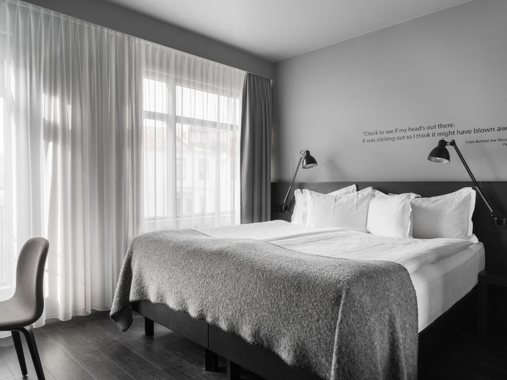 um quarto com uma cama grande e uma janela em Skuggi Hotel by Keahotels em Reiquiavique