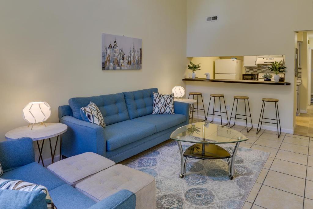 ein Wohnzimmer mit einem blauen Sofa und einem Tisch in der Unterkunft Tallahassee Townhome with Patio Near FSU Campus! in Tallahassee