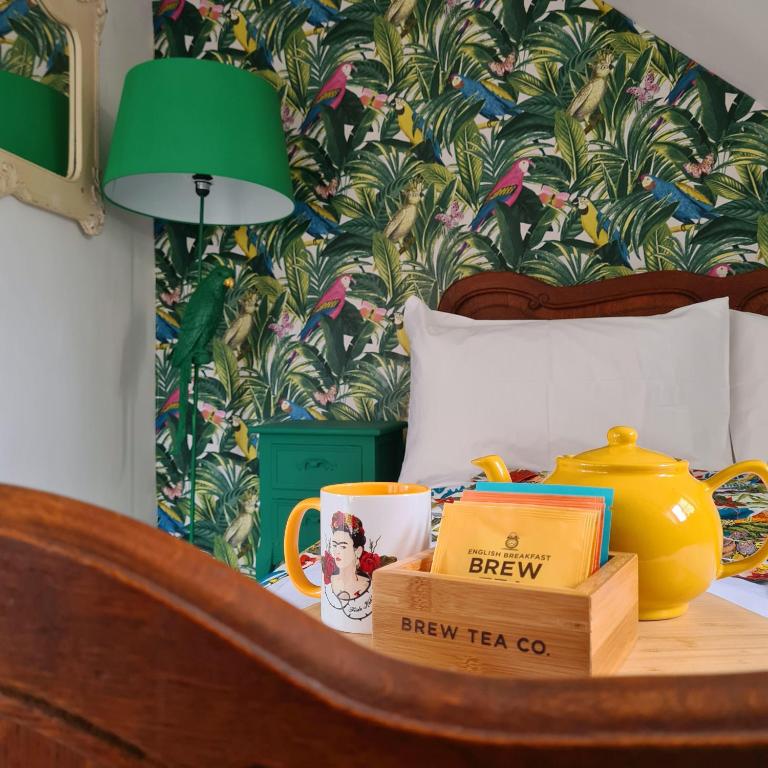 a bedroom with a bed with a green lamp and a table with books at Frida's Cottage Whitby in Whitby