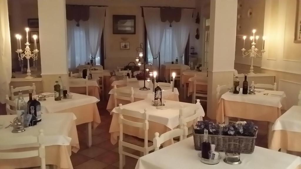塔比亞諾的住宿－Albergo Delle Fonti，餐厅设有白色桌子和蜡烛
