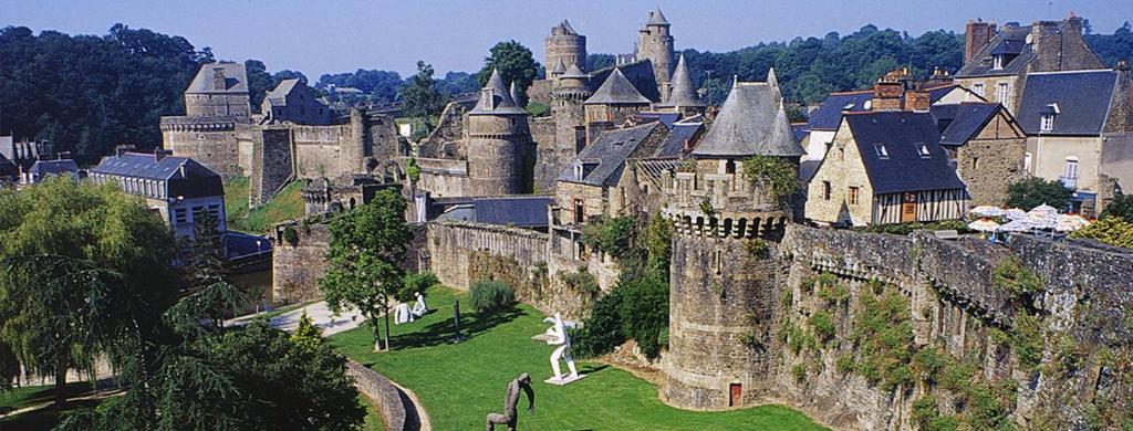 een oud kasteel met een stad op de achtergrond bij Studio des Prés in Fougères