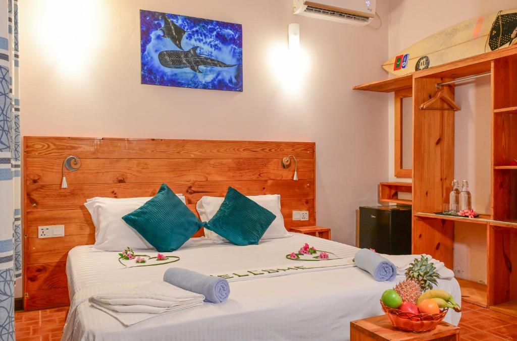 ein Schlafzimmer mit einem Bett mit zwei Teller Essen drauf in der Unterkunft Thulusdhoo Inn in Thulusdhoo